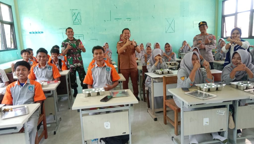 Foto: Siswa SMK Negeri Waringinkurung bersama Danramil, Camat, dan aparat kepolisian saat peluncuran program Makan Bergizi Gratis di Serang, Banten. (30/9/2025).